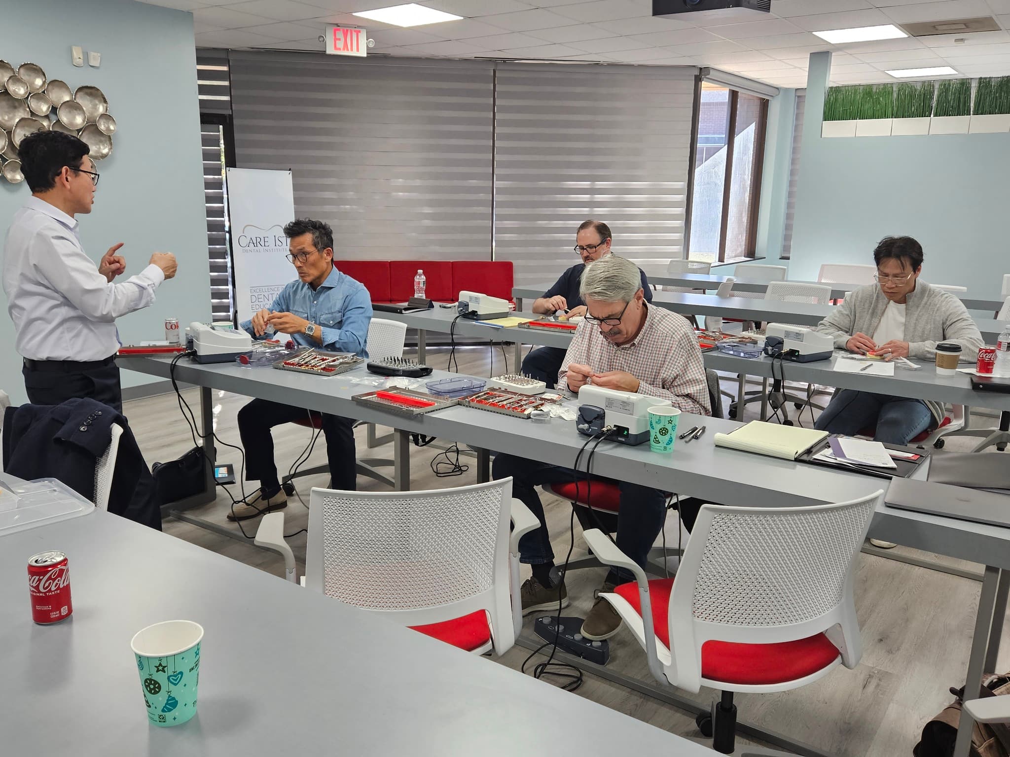 Instructor guiding dental professionals through hands-on workstation training at Care1st
