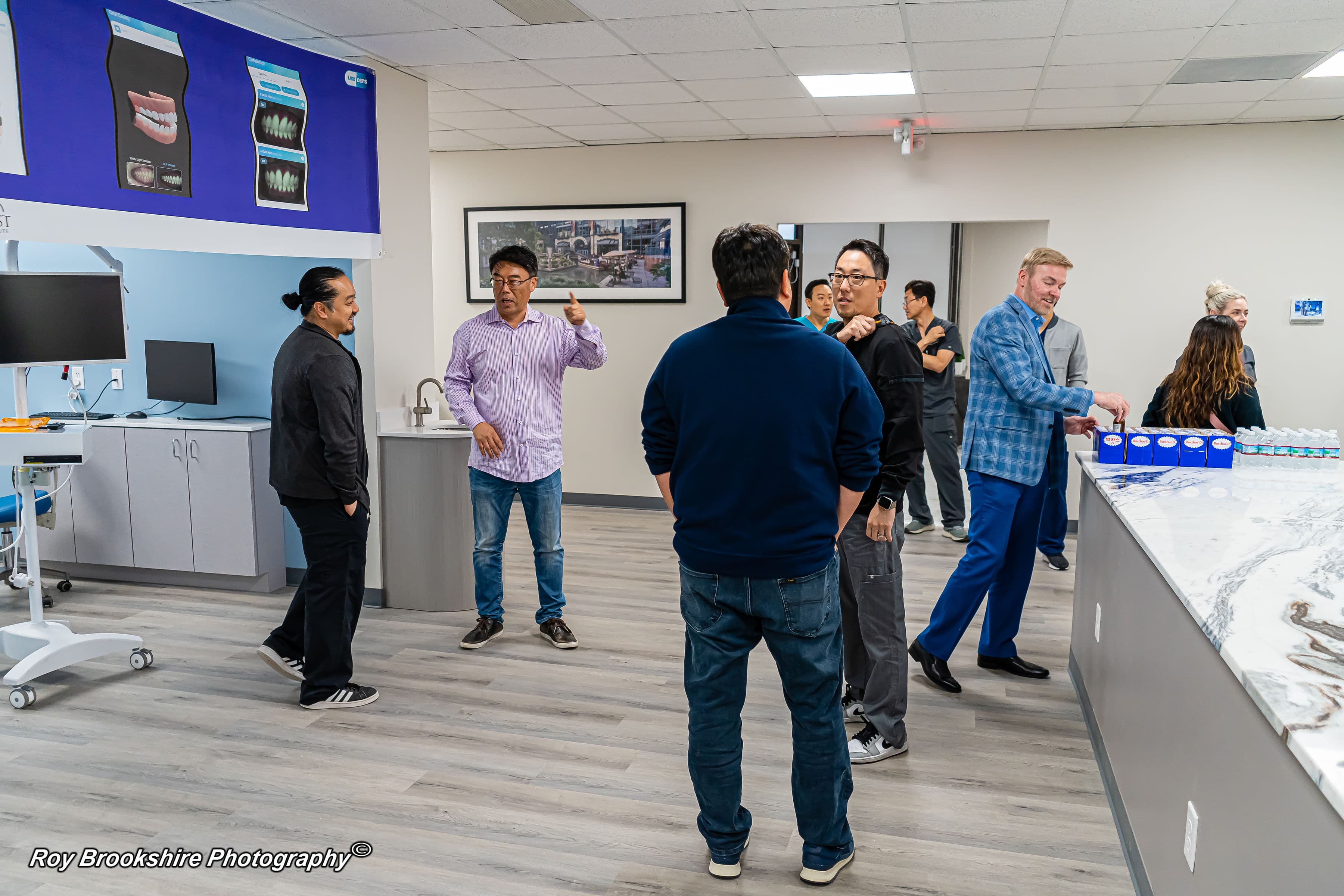 Dental professionals networking in the facility near clinical cabinetry and presentation materials